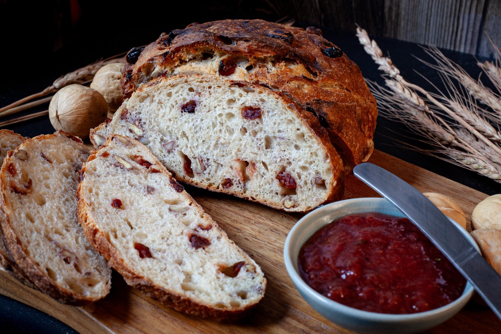 Sliced Cranberry Walnut Sourdough showcasing its chewy crumb and rich inclusions.