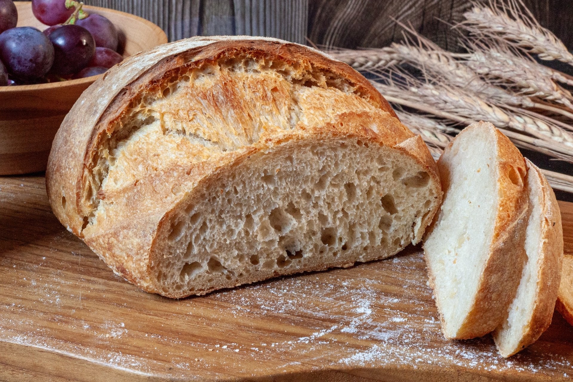 Rustic Country Sourdough Bread loaf resting on a wooden board, showcasing its golden crust.