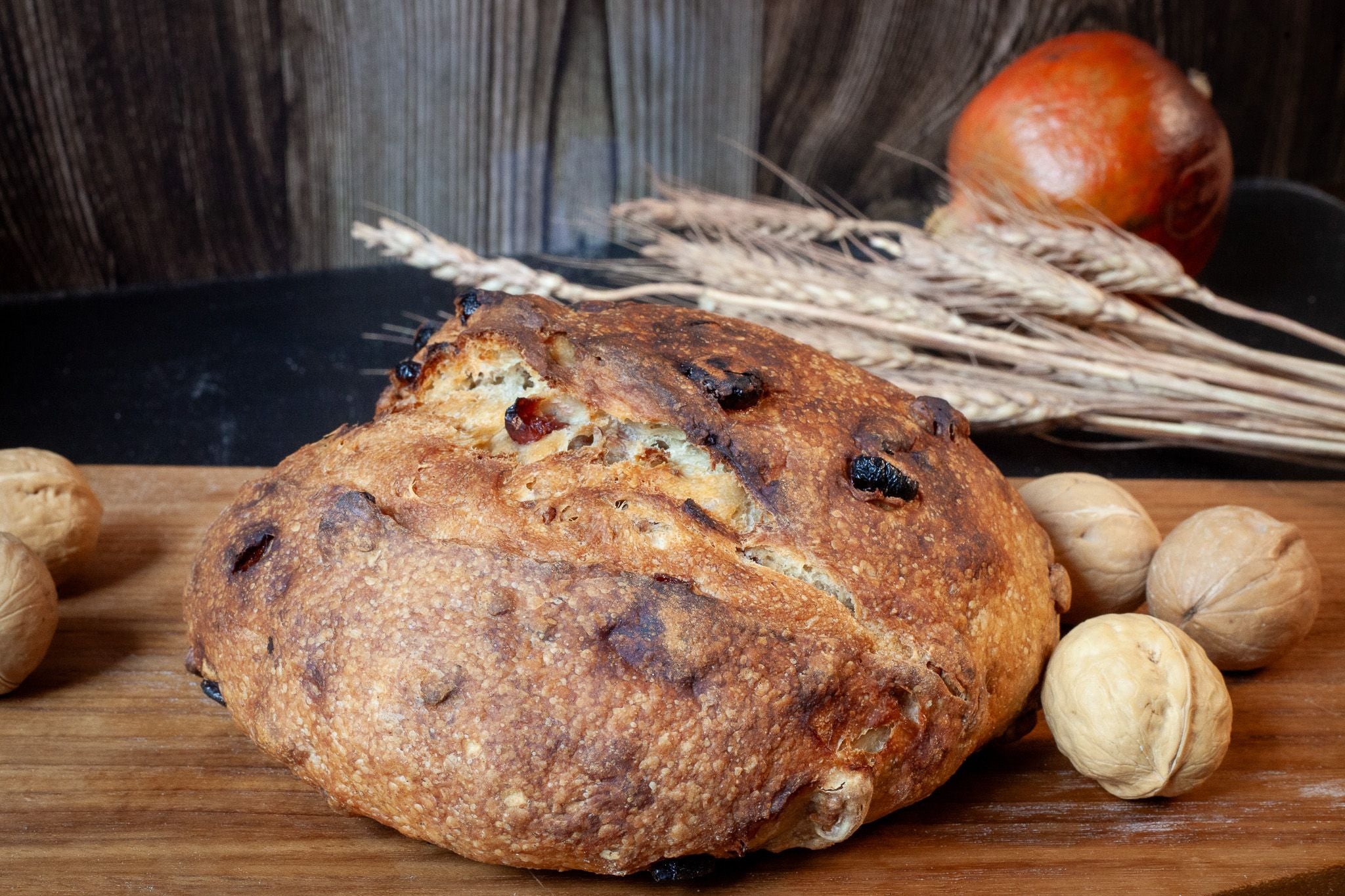 Artisan Cranberry Walnut Sourdough loaf with a golden crust and visible cranberry and walnut pieces.
