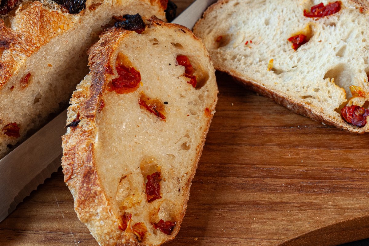 Rustic slices of sourdough bread studded with sun-dried tomatoes and glistening with a subtle layer of truffle oil.