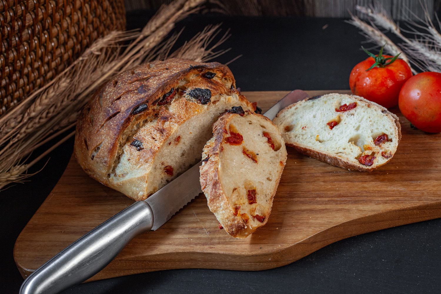 Sliced sourdough bread with visible chunks of sun-dried tomatoes and a hint of truffle oil sheen.