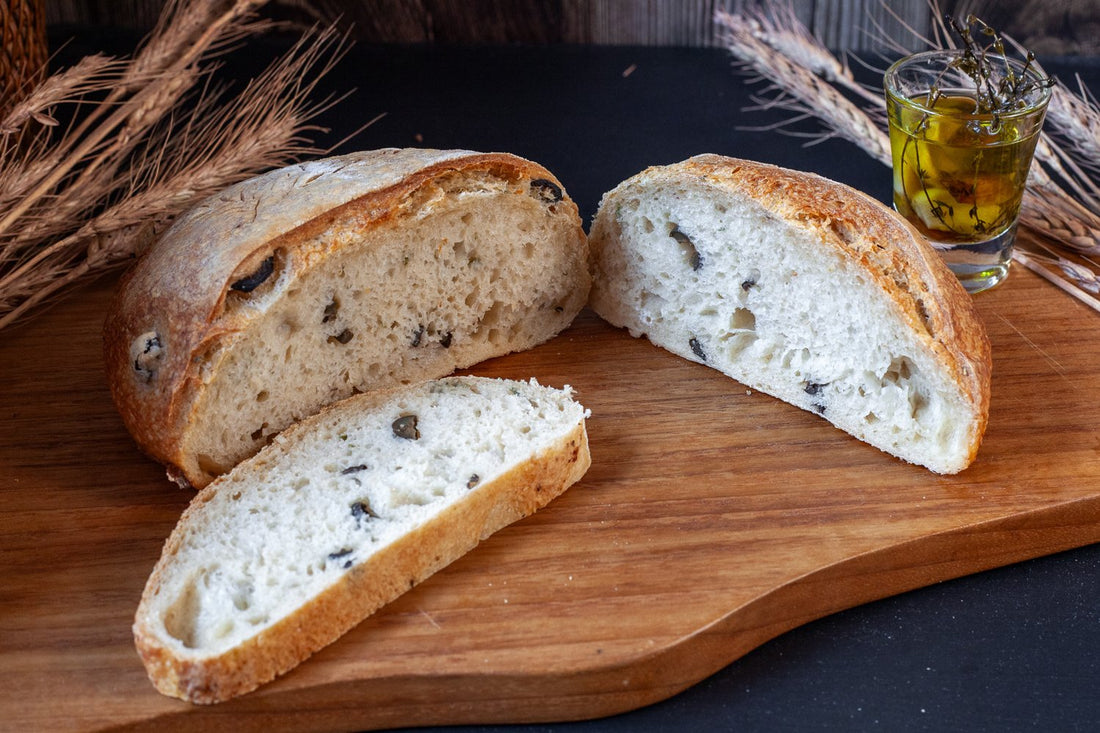 Artisan Olive and Rosemary Sourdough bread with a golden, crusty exterior and aromatic herbs throughout.