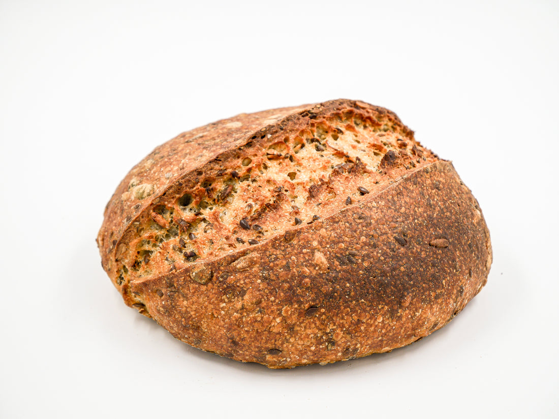 Artisan Seeduction Sourdough loaf with a golden crust and visible seed blend.