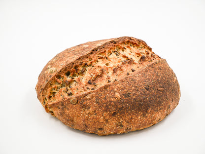 Artisan Seeduction Sourdough loaf with a golden crust and visible seed blend.