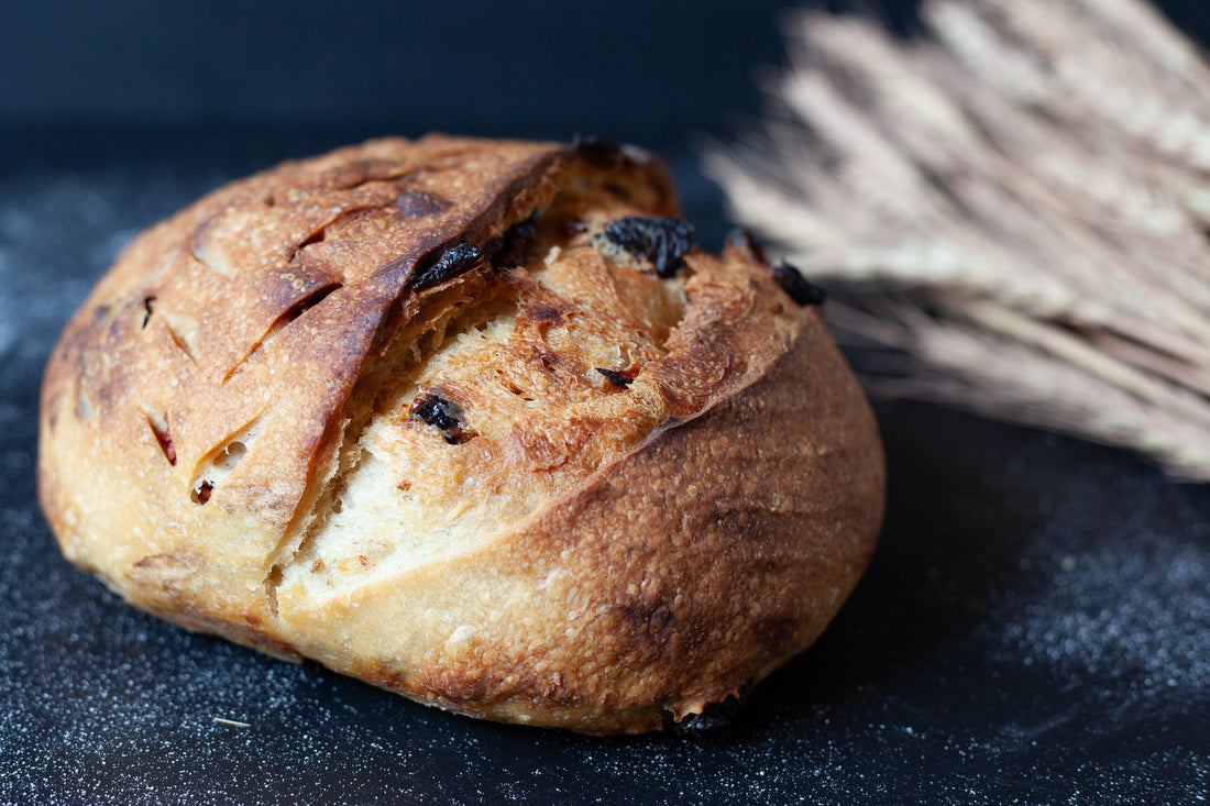Artisan sourdough loaf infused with sun-dried tomatoes and truffle oil, showcasing a golden crust and rustic texture.